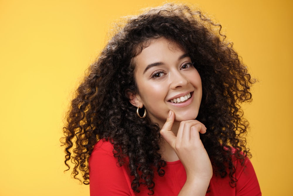 woman with curly hair in red top