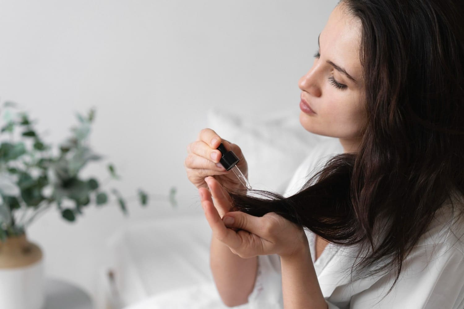 Woman applying hair serum to her hair