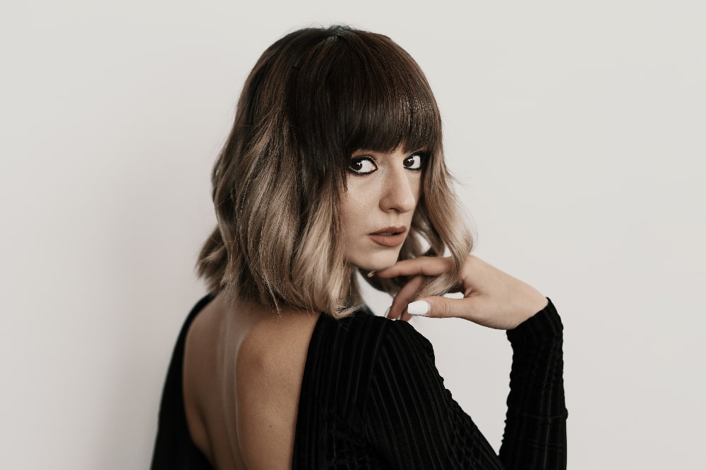 Woman with short bob hairstyle, bangs, and a trendy ombre color