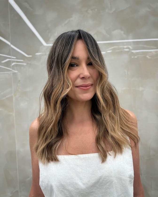 Long brunette hair lightened to soft caramel through the mid-lengths and ends after balayage at HairSocial