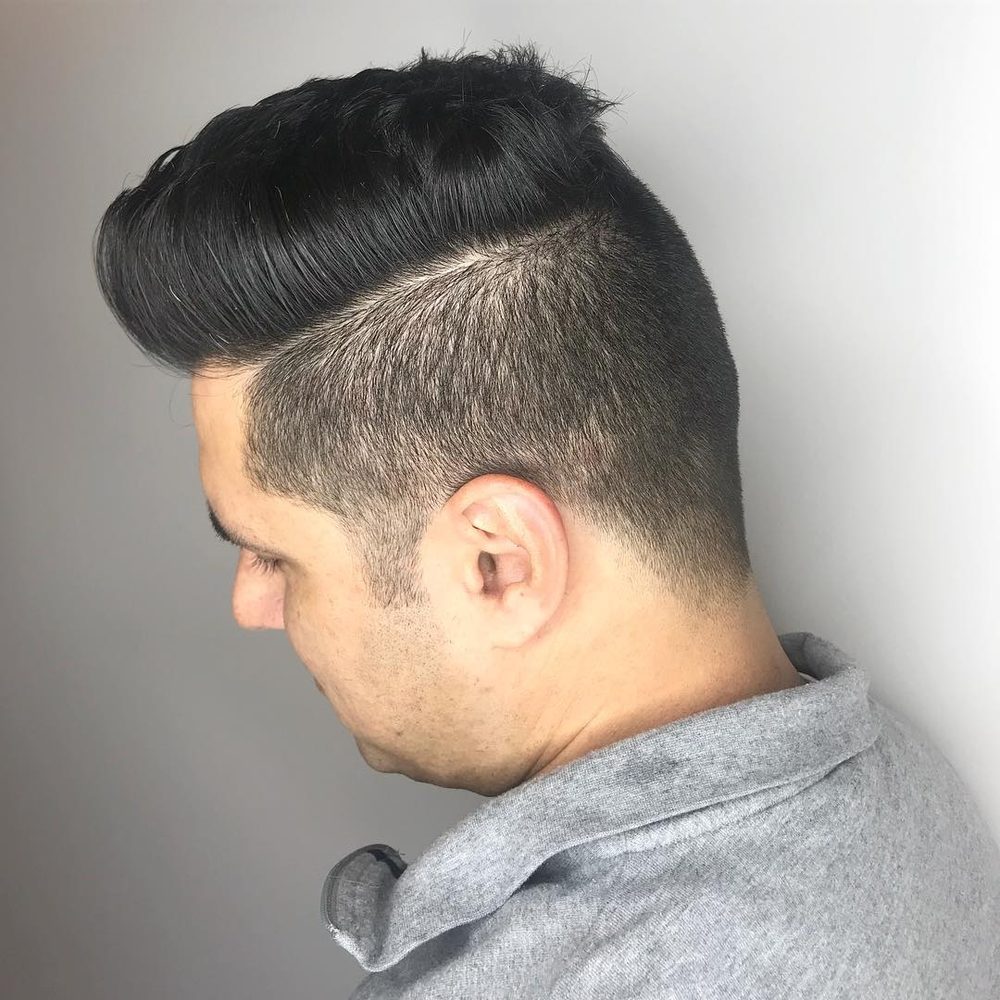 Tapered back and neckline on a men’s haircut, with a hard part and textured length left on top