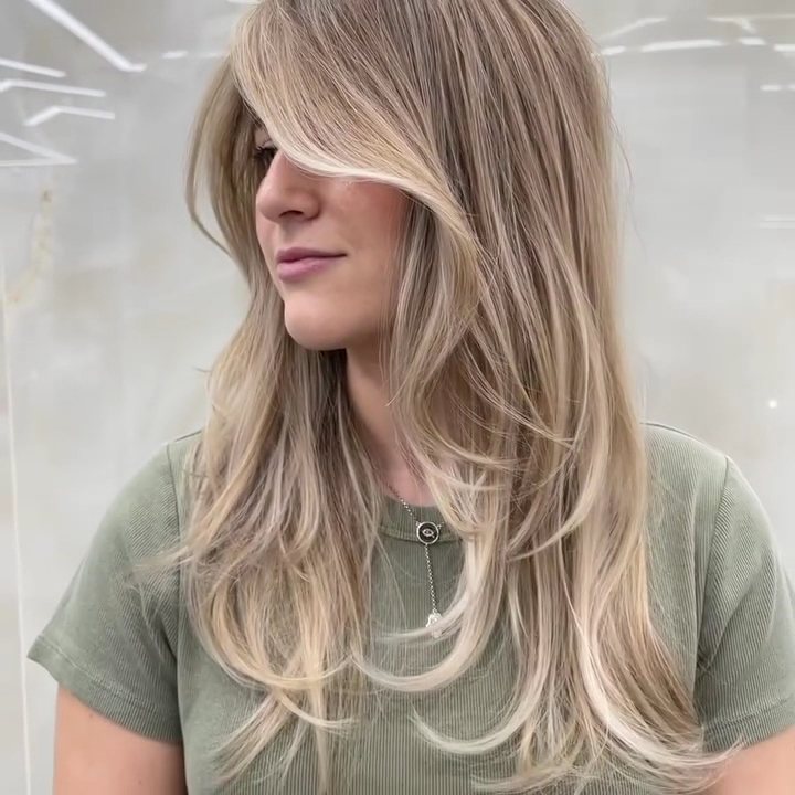 Client with curtain bangs and long soft blonde layers at HairSocial