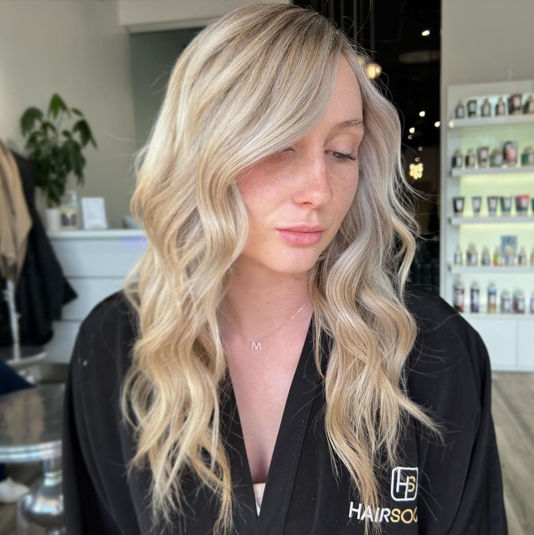 Client with golden blonde balayage curls inside HairSocial