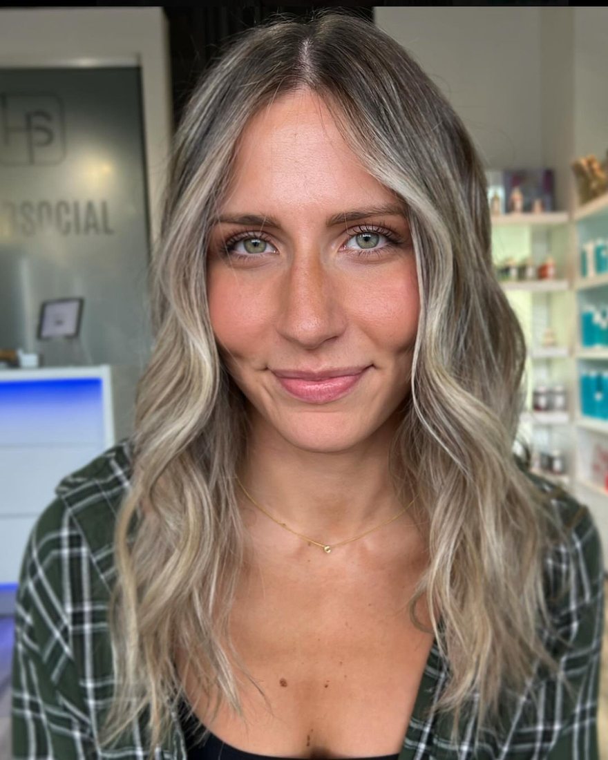 Smiling client with face-framing blonde balayage at HairSocial