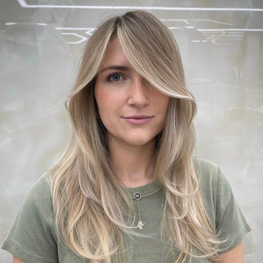 Client with soft blonde face-framing layers at HairSocial
